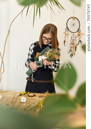 woman holding beautiful autumn bouquet of dry materials woman holding beautiful autumn bouquet of dry materials 76979745