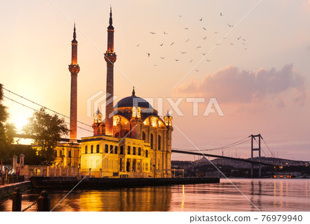 The Ortakoy Mosque and Bosphorus bridge at sunrise with many seagulls, Istanbul 76979940
