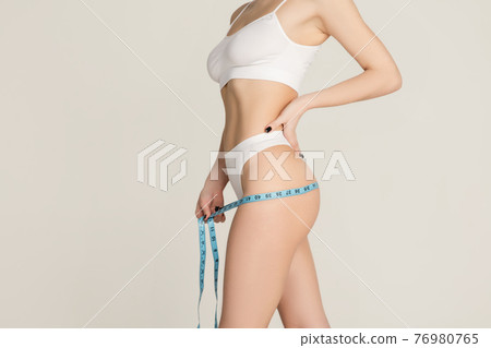 Cropped slim beautiful woman in underwear isolated over gray background. Cropped slim beautiful woman in underwear isolated over gray background. 76980765