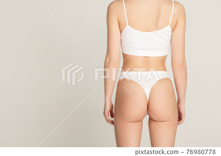 Cropped slim beautiful woman in underwear isolated over gray background. Cropped slim beautiful woman in underwear isolated over gray background. 76980778