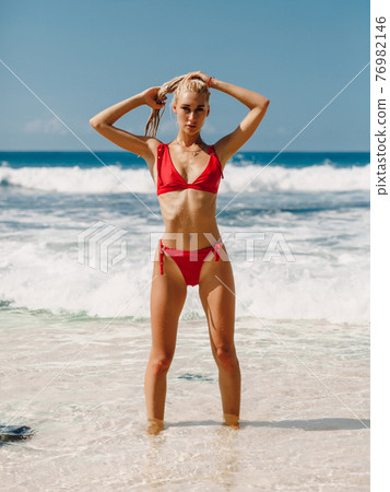 Attractive slim woman in bikini relax at beach in Bali. Caucasian model with ocean Attractive slim woman in bikini relax at beach in Bali. Caucasian model with ocean 76982146