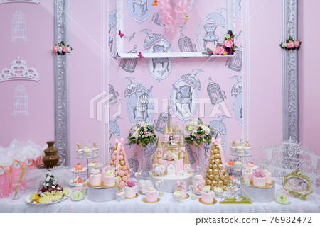 Many delightful sweet cakes and candies on wedding table. Many delightful sweet cakes and candies on wedding table. 76982472