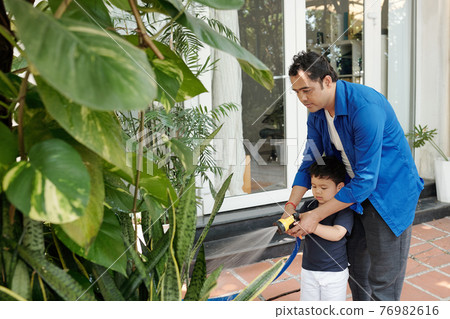 Teaching son watering plants Teaching son watering plants 76982616