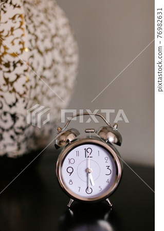 Antique clock in black background. 76982631