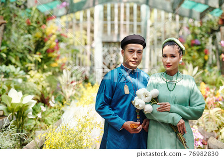 Man and woman in ao dai dresses and headwear Man and woman in ao dai dresses and headwear 76982830
