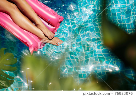 Woman relaxing on floating mattress 76983076