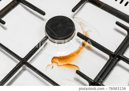 Dirty gas stove and burners after home cooking in the kitchen, close up 76983136