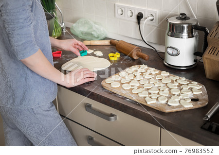 Portrait young adult brunette caucasian woman making dough with roller pin for sweet tasty homemade cookies at home kitchen. Female person housewife mother cooking delicoius healthy handmade pastry Portrait young adult brunette caucasian woman making dough with roller pin for sweet tasty homemade cookies at home kitchen. Female person housewife mother cooking delicoius healthy handmade pastry 76983552