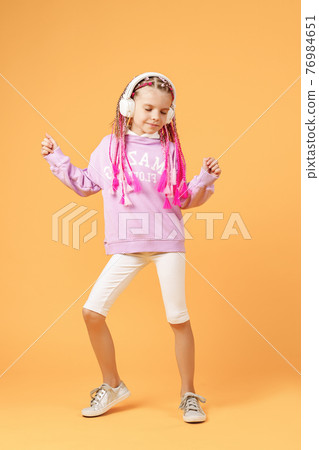 Adorable child in rounded glasses with pink dreadlocks listen to Adorable child in rounded glasses with pink dreadlocks listen to 76984651
