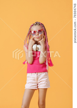 Crazy expressive trendy DJ girl in bright clothes, headphones an 76984748