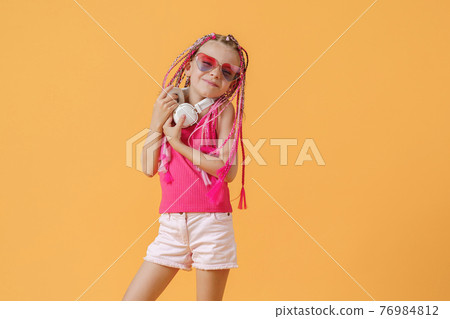 Crazy expressive trendy DJ girl in bright clothes, headphones an 76984812
