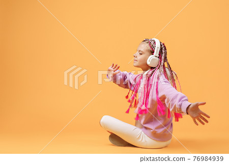 Back view of Adorable child in rounded glasses with pink dreadlo 76984939
