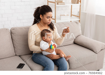 Black Mom Measuring Temperature For Sick Baby Having Fever Indoor Black Mom Measuring Temperature For Sick Baby Having Fever Indoor 76984982