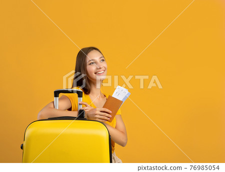 Happy woman posing over yellow studio background, ready for vacation 76985054