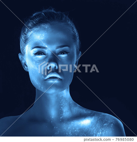 Creative portrait of surreal girl with glowing skin, blue tone in dark 76985080