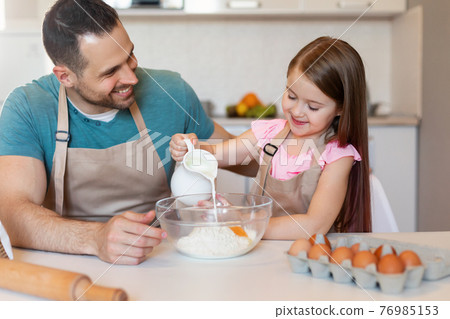 Daddy And Little Daughter Making Dough Baking Cake In Kitchen 76985153