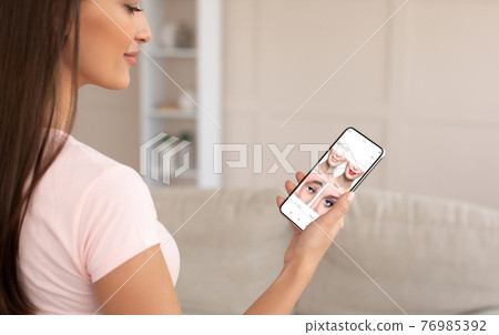 Augmented Reality Beauty App. Woman Trying Different Makeup Online Augmented Reality Beauty App. Woman Trying Different Makeup Online 76985392