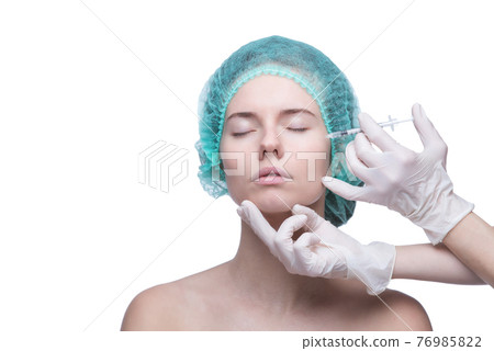 Portrait of young Caucasian woman getting cosmetic injection Portrait of young Caucasian woman getting cosmetic injection 76985822