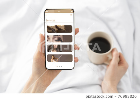 Woman Holding And Showing Smart Phone With Beauty Sevices 76985826