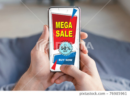 Unrecognizable man shopping online while chilling at home, using smartphone 76985961
