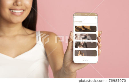 Woman Holding And Showing Smart Phone With Beauty Sevices Woman Holding And Showing Smart Phone With Beauty Sevices 76985970