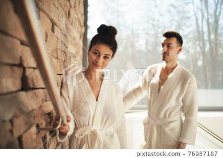 Portrait of young couple in spa resort, walking up the stairs. 76987187
