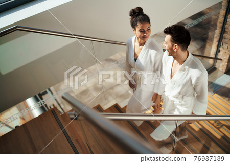 Top view of young couple in spa resort, walking up the stairs. Top view of young couple in spa resort, walking up the stairs. 76987189