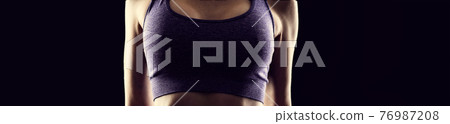 Slim athletic woman on black background Slim athletic woman on black background 76987208
