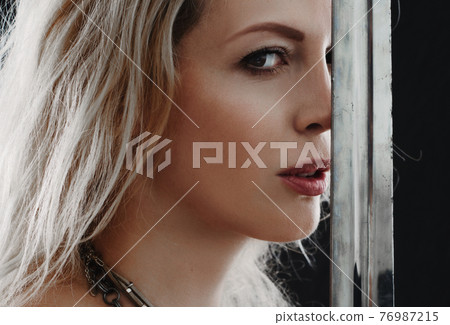 Beautiful blong viking woman holding sword blade Beautiful blong viking woman holding sword blade 76987215