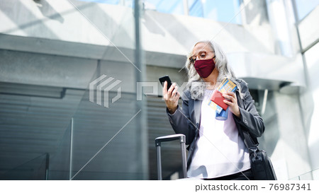 Senior woman in airport lounge, coronavirus, travel and new normal. 76987341