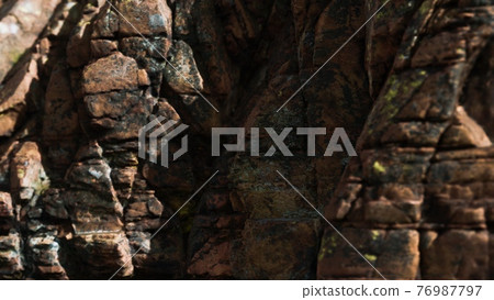 Solid rock with cracks close up 76987797