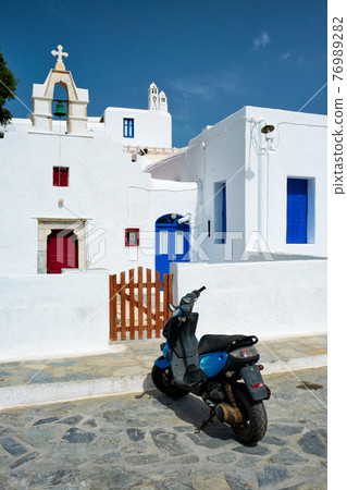Motorcycle parked near orthodox christian church 76989282