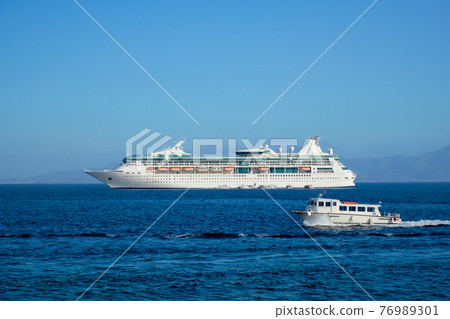 Boat and cruise liner is Aegean sea. Chora, Mykonos island, Greece Boat and cruise liner is Aegean sea. Chora, Mykonos island, Greece 76989301