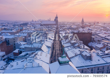 Krakow Old Town in winter. Snow on roofs at Old Town in winter Krakow Poland at sunset. Krakow Old Town in winter. Snow on roofs at Old Town in winter Krakow Poland at sunset. 76989574