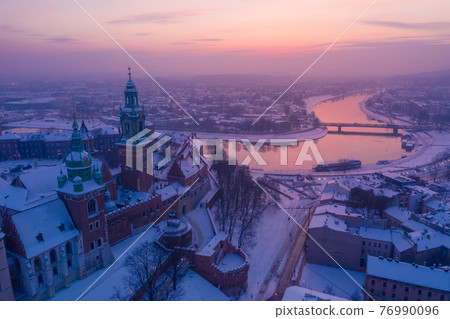 Wawel Royal Castle in winter. Snow on roofs of Wawel castle cathedral and Vistula river in Krakow Wawel Royal Castle in winter. Snow on roofs of Wawel castle cathedral and Vistula river in Krakow 76990096