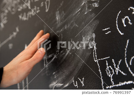 Mathematical formulas on dark black chalk board Mathematical formulas on dark black chalk board 76991397