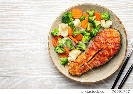 Grilled salmon steak with vegetables salad from above copy space Grilled salmon steak with vegetables salad from above copy space 76991707