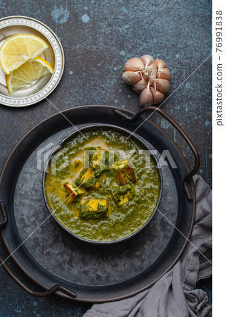 Indian dish Palak Paneer in bowl on rustic stone table Indian dish Palak Paneer in bowl on rustic stone table 76991838