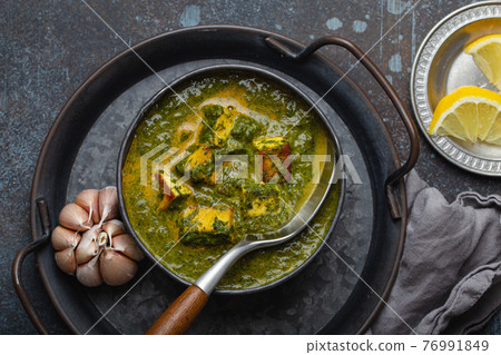 Indian dish Palak Paneer in bowl on rustic stone table Indian dish Palak Paneer in bowl on rustic stone table 76991849