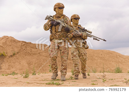 Equipped and armed special forces soldiers in the desert. 76992179
