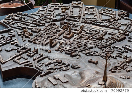 Model city made bronze close-up, houses and streets are not detailed, some buildings are more detailed highlighted in golden color 76992779