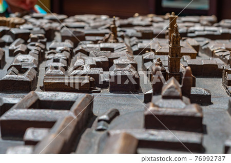 Model city made bronze close-up, houses and streets are not detailed, some buildings are more detailed highlighted golden color  76992787