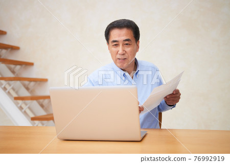 A man having an online meeting in the living room 76992919
