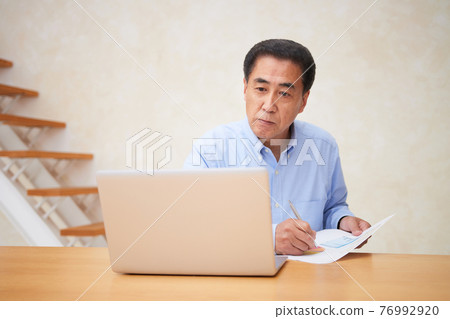 A man having an online meeting in the living room 76992920