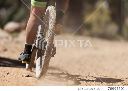 Mountain biker riding on bike singletrack trail, back view of mountain biker. Mountain bike race Mountain biker riding on bike singletrack trail, back view of mountain biker. Mountain bike race 76993301