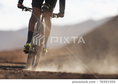Mountain biker riding on bike singletrack trail, back view of mountain biker. Mountain bike race 76993309