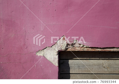 Photo of old wall with peeling pink paint 76993344