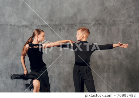 Young couple little boy and girl dancing in ballroom dance Jive 76993488