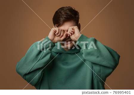 upset crying young guy in green sweatshirt upset crying young guy in green sweatshirt 76995401