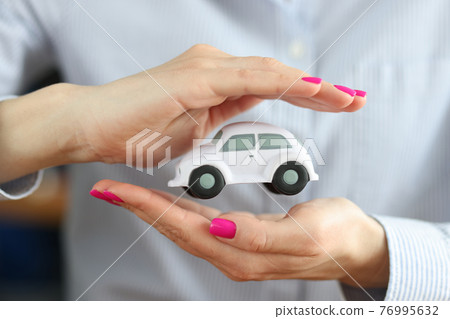 Inside female hands is white small car Inside female hands is white small car 76995632